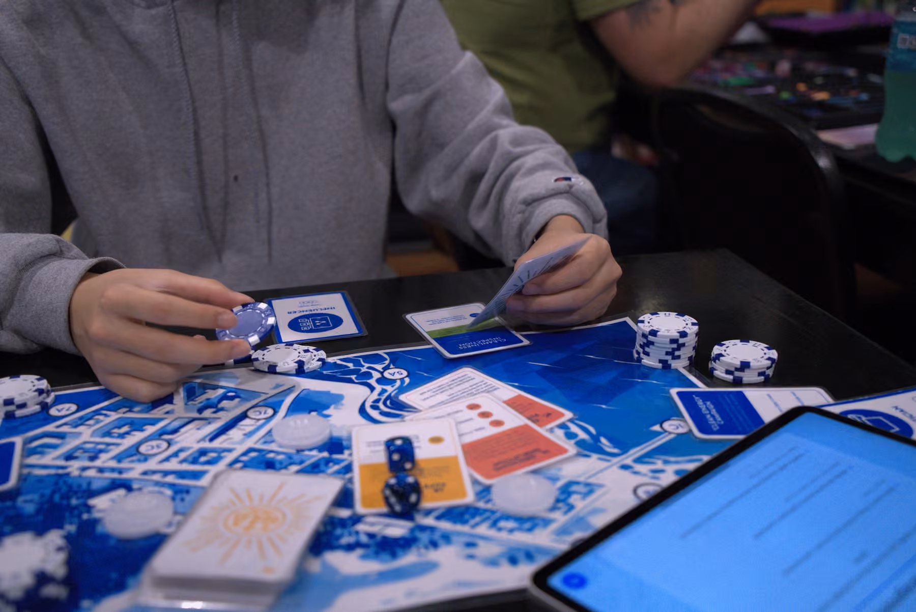Player considering a card and Credit token during TideBound